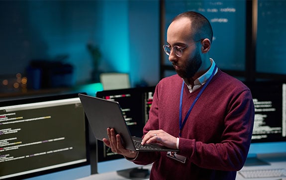 Cyber security professional looking at a laptop