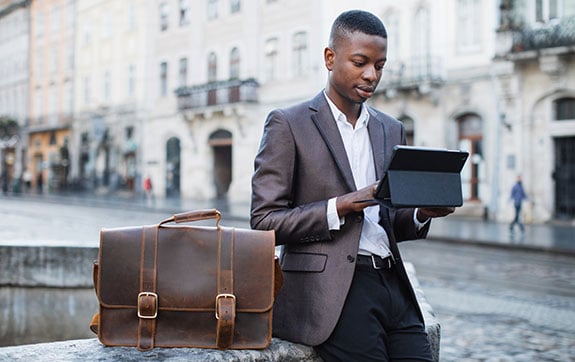 Finance student working on an iPad in street